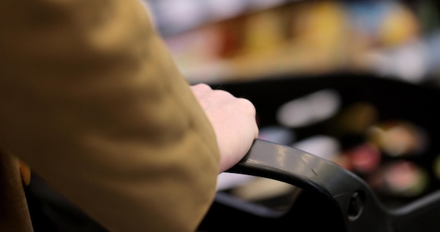 Ręce pchające wózek w supermarkecie lub centrum handlowym Rozmycie tła
