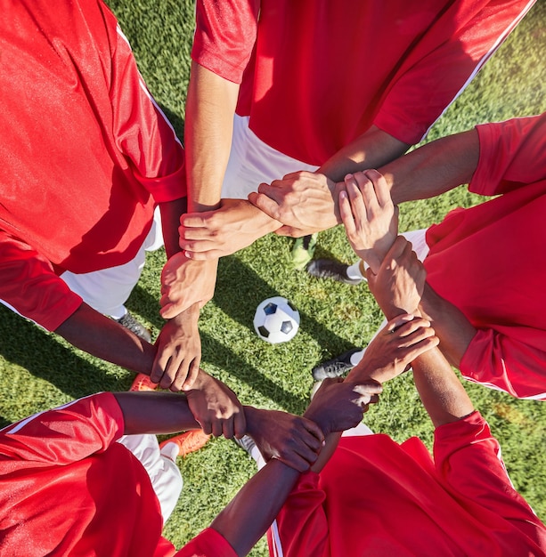 Zdjęcie ręce piłkarskie i sport zespołowy ze wsparciem przed meczem lub treningiem z piłką w kręgu grupa mężczyzn szczyt boiska piłkarskiego i trawa z ludźmi wykazującymi motywację zaufania i pracę zespołową