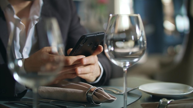 Ręce płci męskiej wpisując telefon przy stole w restauracji Biznesmen za pomocą smartfona