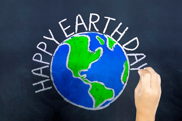 Ręce rysują kulę ziemską i piszą tekst Happy Earth Day