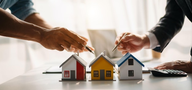 Ręce sprzedawcy Model domu Mały domek z zabawkami Mały kredyt hipoteczny Ubezpieczenie majątkowe i koncepcje nieruchomościxA