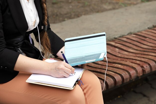 Ręce Trzymają Tablet I Notatnik, Na Którym Robi Notatki