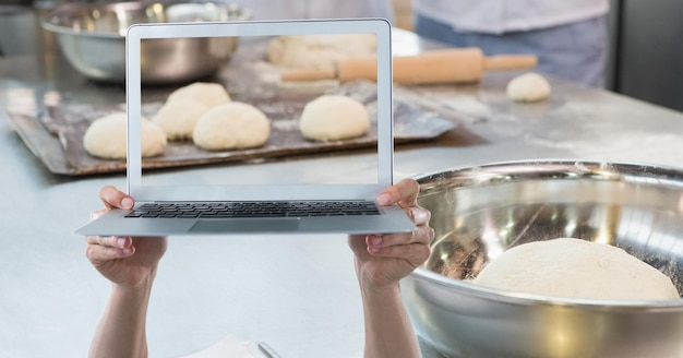 Zdjęcie ręce trzymające laptopa podczas fotografowania ciasta