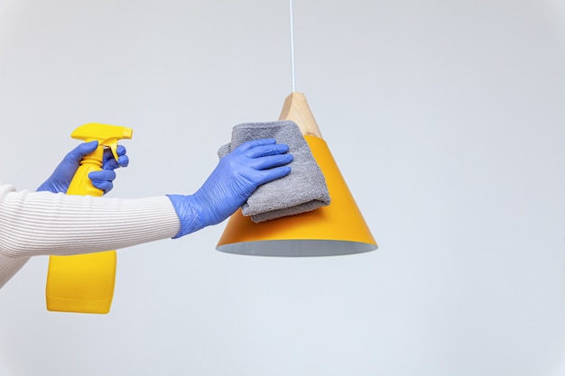 Zdjęcie ręce w rękawiczkach usuwanie kurzu czyszczenie żyrandol lampy elektrycznej