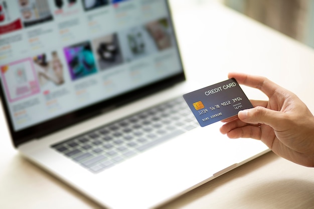 Ręce za pomocą laptopa i karty kredytowej do płatności online