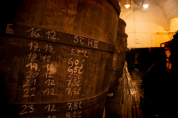 Ręczne adnotacje na drewnianych beczkach piwa w procesie fermentacji w zabytkowym browarze