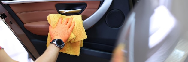 Ręczne czyszczenie wewnętrznego panelu drzwi samochodu ściereczką z mikrofibry