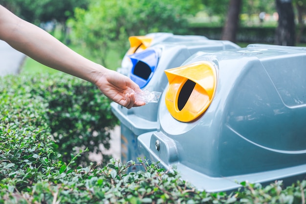 Ręczne wrzucanie plastikowej torby do kosza. Koncepcje ochrony środowiska i globalnego ocieplenia.