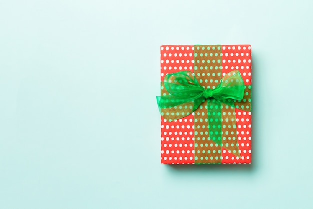 Ręcznie owinięty świąteczny prezent w postaci papieru z zieloną wstążką na niebiesko