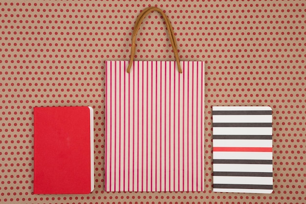 Ręcznie robiona torba na zakupy w paski i notatniki na papierowym tle w czerwone kropki