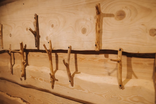 Ręcznie robione drewniane wieszaki są przymocowane do ściany w drewnianym domu