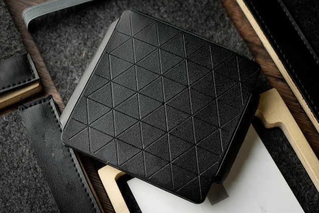 Ręcznie robiony czarny portfel wykonany z prawdziwej skóry na drewnianym tle Zbliżenie widok z góry