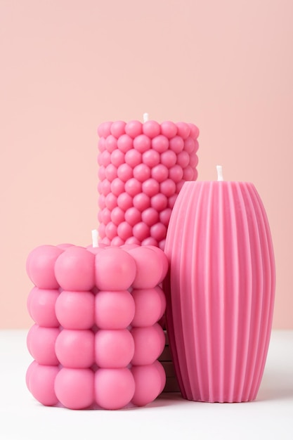 Ręcznie robiony wosk z oliwek różne formy różowa świeca na pastelowym różowym i białym tle bichromii Zrównoważony rozwój wegańska świeca naturalne materiały Minimalistyczne nowoczesne zdjęcie Kopiuj przestrzeń pionowo