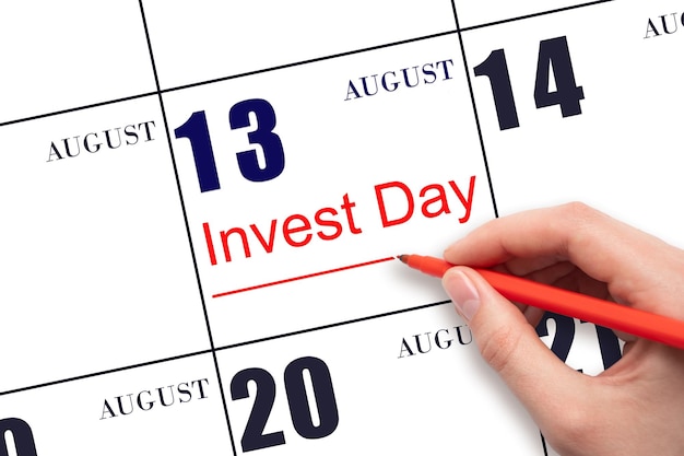 Ręcznie rysując czerwoną linię i pisząc tekst Invest Day w dniu kalendarzowym 13 sierpnia Koncepcja biznesowa i finansowa