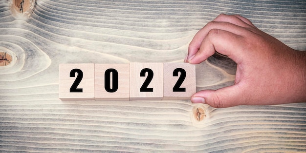Zdjęcie ręcznie ułóż miejsce drewniany sześcian numer 2022 na tle widoku z góry na stole koncepcja nowego roku