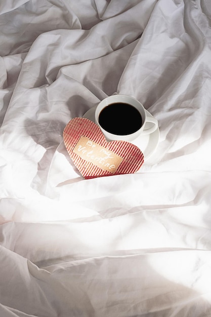 Ręcznie wykonane serce i filiżanka do kawy na łóżku Przyjemny ranek Walentynek.