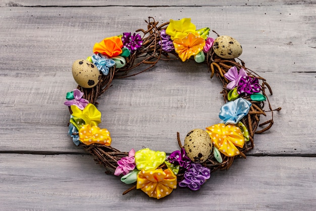 Zdjęcie ręcznie wykonany wielkanocny wieniec wiklinowy z jajkami przepiórczymi i ręcznie robionymi kwiatami