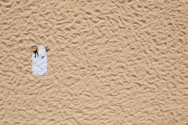 Ręcznik z akcesoriami plażowymi na piasku widok z góry Miejsce na tekst