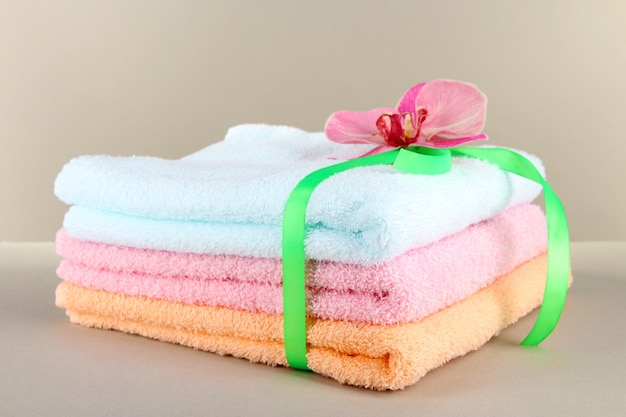 Ręczniki przewiązane wstążką na szarym tle