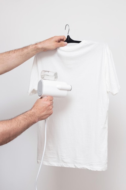 Ręczny steamer do ubrań Tshirt steam na białym tle