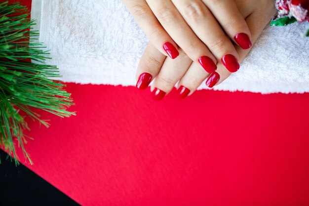 Red Christmas manicure zrobić w studio urody na tle Bożego Narodzenia.