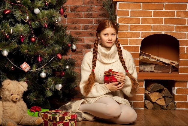 Redhair kobieta z prezentem świątecznym we wnętrzu domu