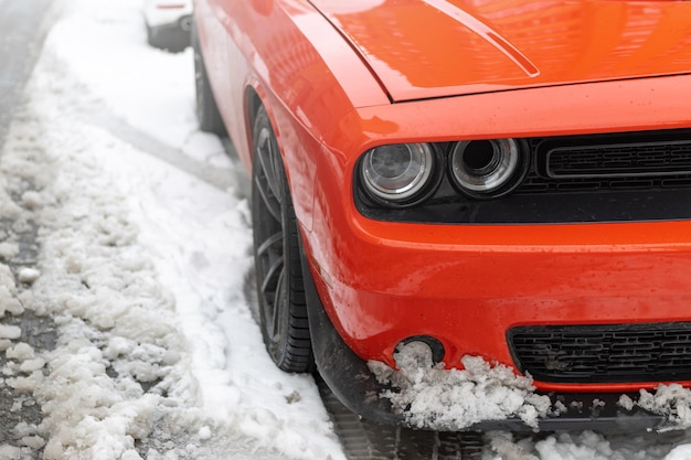 Reflektory i sadza czerwonego samochodu sportowego na śniegu Beautiful Muscle car in snow