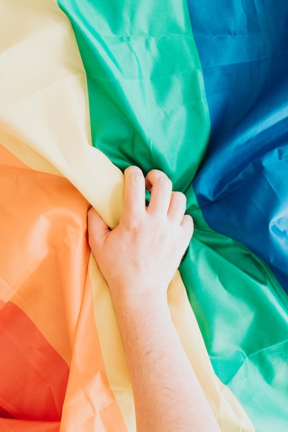 Ręka chwytająca flagę LGBT walczącą o prawa ludzi Kolorowy obraz z miejscem na kopię