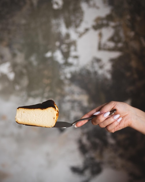 Ręka cukiernika trzyma kawałek ciasta na cukierni