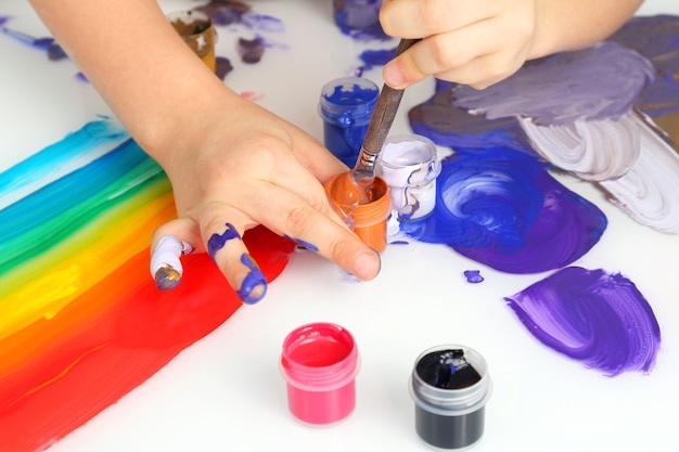 Ręka dziecka rysuje kolory malarskie