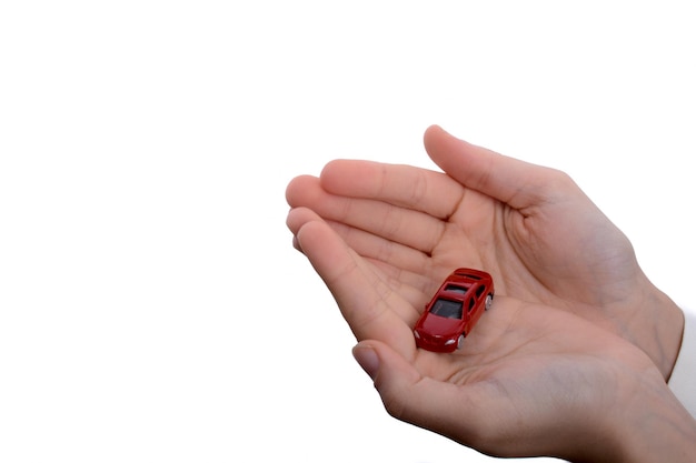 Ręka dziecka trzyma czerwony samochód