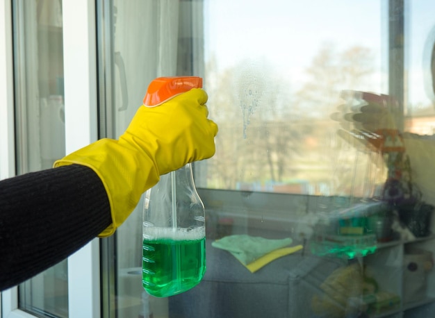 Ręka Dziewczyny W Rękawiczce Myje Okna Za Pomocą Koncepcji Prac Domowych Z Detergentem W Sprayu