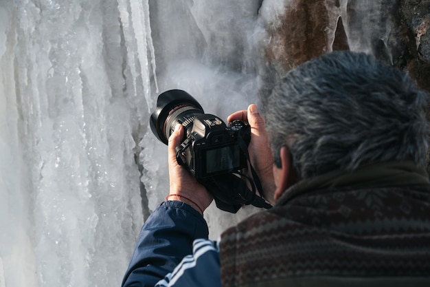 Ręka fotografa z aparatem DSLR robi zdjęcia