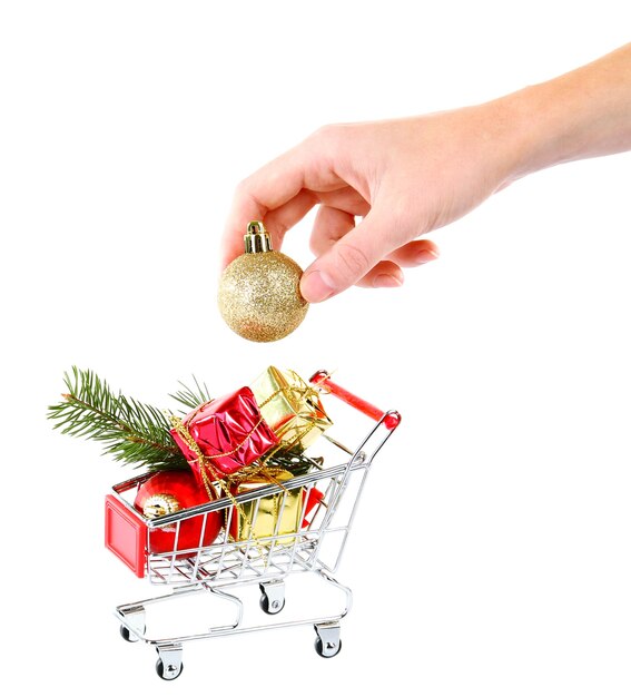 Ręka i prezenty świąteczne w wózku na zakupy, na białym tle