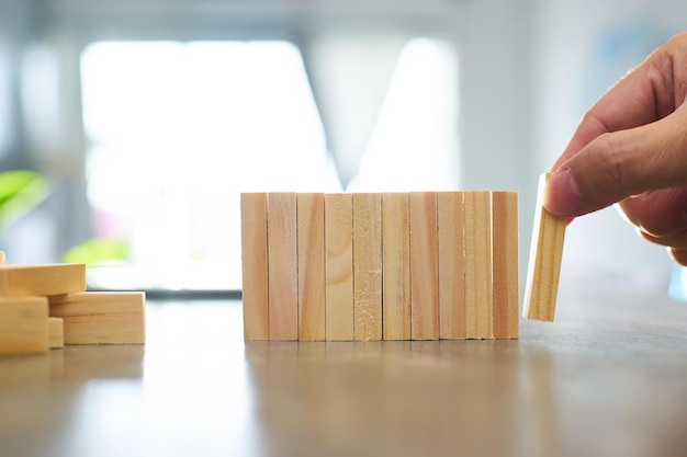 Ręka inżyniera grająca w drewniany klocek Wzrost w koncepcji biznesowej i celu