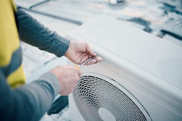 Zdjęcie ręka klimatyzator i konserwacja z mężczyzną pracownikiem budowlanym na dachu, aby zainstalować system chłodzenia inżynier naprawy hvac i ac z męską złotą rączką obsługującą zbliżenie budynku