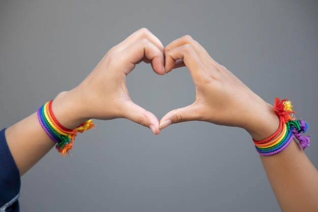 Zdjęcie ręka kobiet lgbt trzymających się razem, tworzących kształt serca z tęczową wstążką symbol koncepcji dumy lgbt ludzie lgbtq kampania praw lgbt małżeństwo tej samej płci