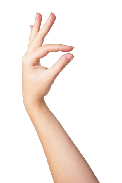 Ręka kobiety mierząca niewidoczne małe przedmioty na białym tle