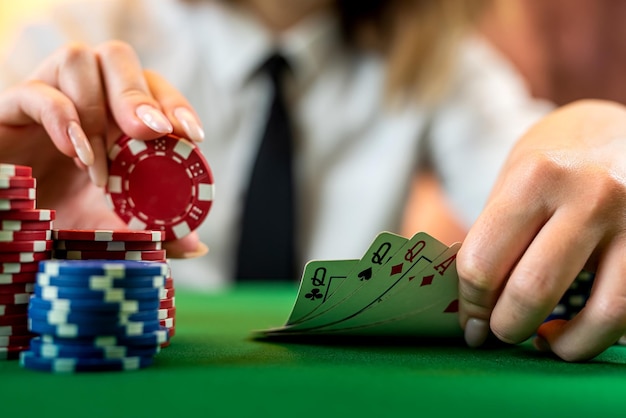 Ręka kobiety na stosie żetonów do pokera przy okrągłym stole do pokera