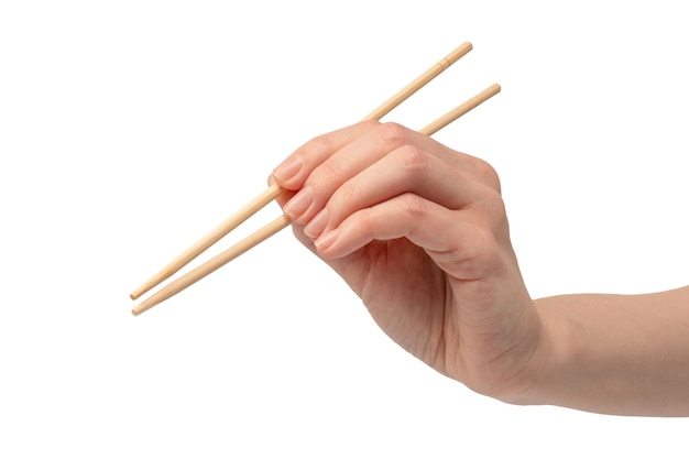 Ręka kobiety trzymająca drewniane pałeczki do sushi odizolowane na białym tle