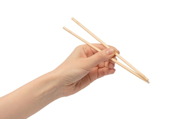 Ręka kobiety trzymająca drewniane pałeczki do sushi odizolowane na białym tle