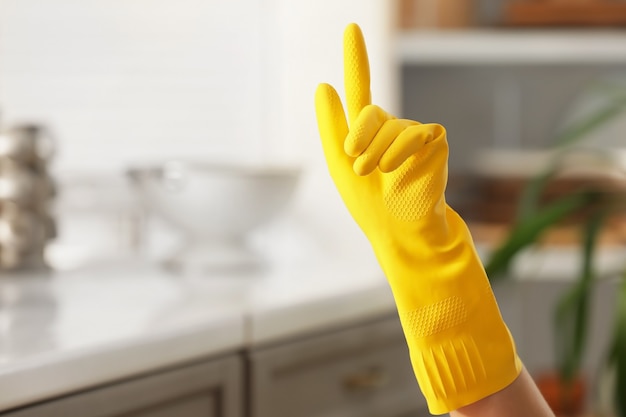 Ręka kobiety w gumowej rękawiczce w kuchni