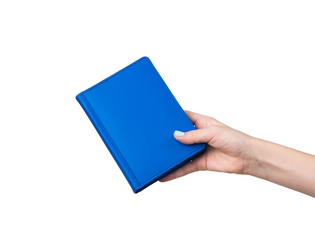 Ręka kobiety z niebieskim notebookiem na białym tle na białej powierzchni