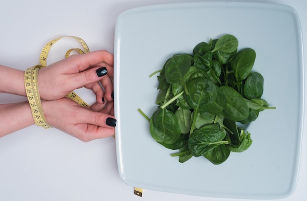 Ręka kobiety z taśmą mierniczą związana ręce kobiety z dietą mierniczą i koncepcją zdrowego jedzenia