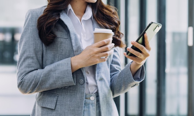 Ręka kobiety za pomocą smartfona i laptopa w odkrytym parku przyrody i zachodzie słońca na niebie z bokeh jasnym abstrakcyjnym tłem Technologia biznesowa i koncepcja pracy niezależnej Vintage tone filter color style