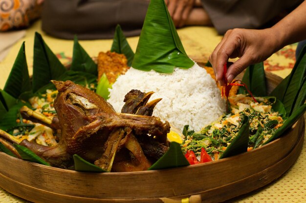 Ręka kobiety zdobi jawajską tradycję tumpeng