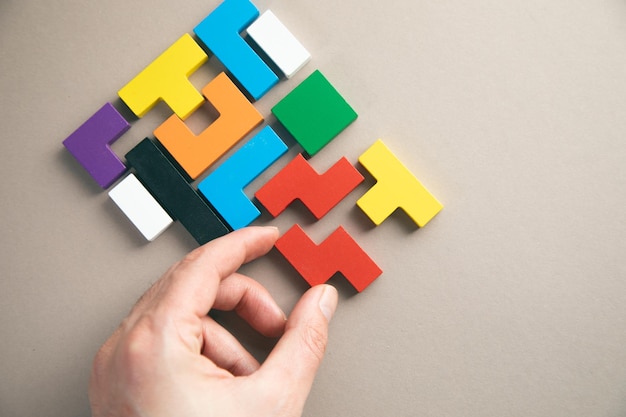 Ręka łącząca Blok O Geometrycznym Kształcie Z Kolorowymi Drewnianymi Puzzlami