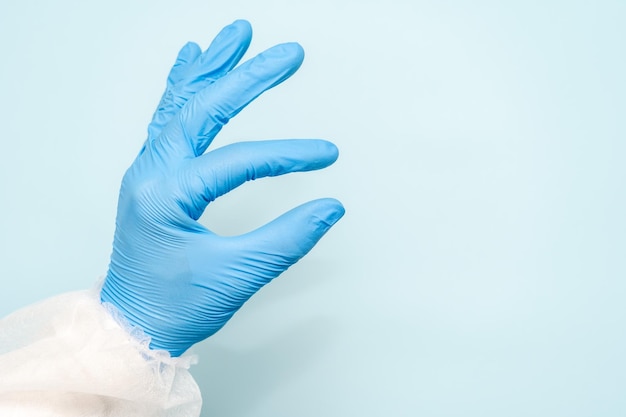 Ręka lekarza w niebieskiej rękawiczce, jak coś trzyma