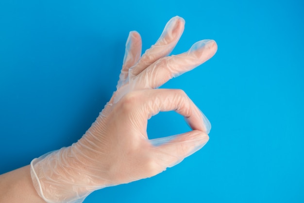 Ręka Lekarza W Rękawice Medyczne Lateksowe Podejmowania Ok Znak Na Niebieskim Tle