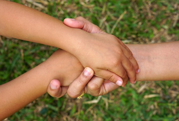 Ręka matki trzymająca rękę małej dziewczynki na tle bokeh Koncepcja miłości i rodziny